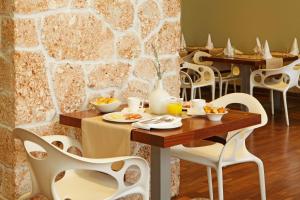 a dining room with tables and chairs and a stone wall at Boutique Hotel Bol in Bol