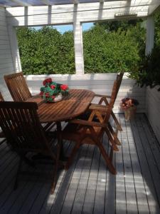 een houten tafel en 2 stoelen op een veranda bij Rosendahl in Ålem
