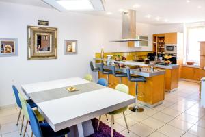 uma cozinha e sala de jantar com mesa e cadeiras em La Sainte Famille em Lourdes