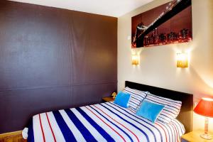 a bedroom with a bed with blue and white pillows at La Sainte Famille in Lourdes