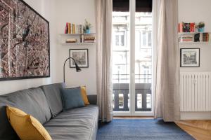 - un salon avec un canapé et une fenêtre dans l'établissement Appartamento dietro Fontana del Nettuno, à Bologne