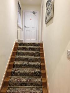 a set of stairs leading to a white door at Lanark Residence in Edinburgh