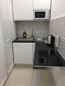 a small kitchen with a sink and a microwave at Lanark Residence in Edinburgh