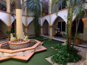 un patio con una fuente en un edificio con palmeras en Gran SAHARA en Playa del Carmen