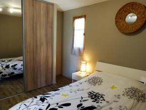 una camera da letto con un letto e uno specchio di Magnifique chalet vue mer, a quelques minutes des plages a Olmeto