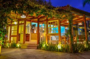 a home with a lit up facade at night at Pousada Maré Mansa in Paraty