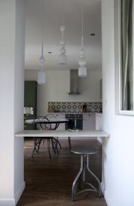 a white kitchen with a table and a stool at Charmète in Aix-les-Bains