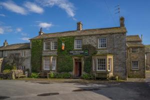 un viejo edificio de piedra con hiedra. en The Falcon Inn en Arncliffe