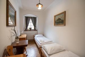 a room with two beds and a table and a window at Restaurace a penzion Stará pošta in Bečov nad Teplou