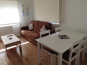 a living room with a white table and a couch at Apartamento Calzada II in Santiago de Compostela