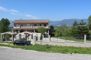 a car parked in front of a house with a fence at B&B Il Melograno in Roccacasale