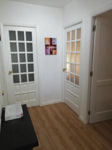 een kamer met twee witte deuren en een tafel bij Apartamento Calzada II in Santiago de Compostela