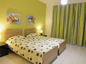 een slaapkamer met een bed in een kamer bij Tas-Sellum Residence in Mellieħa