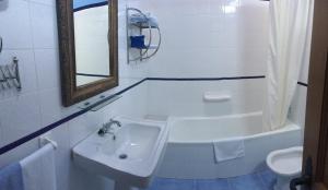 a bathroom with a sink and a tub and a toilet at Posada Rural El Trenti de Corona in Valoria