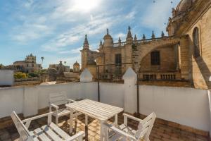stół i 2 krzesła na balkonie z budynkiem w obiekcie Loft Catedral Jerez w mieście Jerez de la Frontera