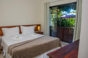 um quarto de hotel com uma cama e uma grande janela em Pousada Maré Mansa em Paraty