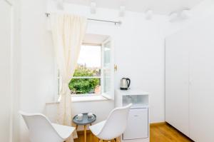 Habitación blanca con sillas blancas y ventana en Cinema View House en Dubrovnik