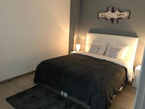 1 dormitorio con 1 cama con una cruz en la pared en Appartement proche Mer en Berck-sur-Mer