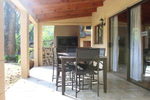 een veranda met een tafel en stoelen op een patio bij Dragon Peaks Mountain Resort in Champagne Valley