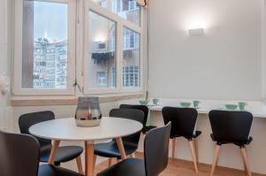a room with a table and chairs and windows at NLC Rooms & Suites in Lisbon