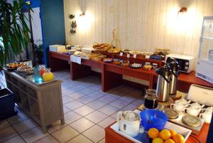 ein Buffet mit viel Essen auf in der Unterkunft Le Bretagne - Hôtel Spa & Sauna in Douarnenez