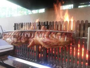 a ham is cooking on a grill with flames at Le Prieuré in Saint-Dalmas-de-Tende