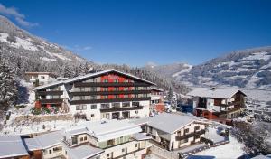 a building in the mountains with snow on the ground at Hotel Bruno in Fügen