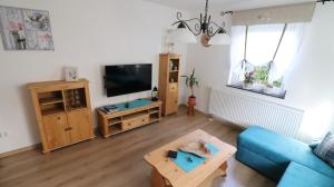 uma sala de estar com um sofá azul e uma televisão em Ferienhaus Steinbach em Oberasbach