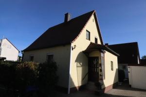 une maison blanche avec un toit noir et un garage dans l'établissement Ferienhaus Steinbach, à Oberasbach