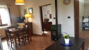 a living room with a stove and a dining room at Casa Vacanze Fornace in Buonconvento