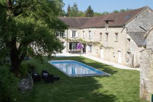 a swimming pool in a yard next to a building at Le clos de Chaussy in Chaussy