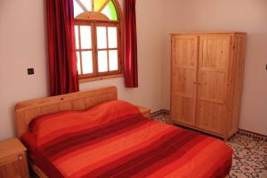 een slaapkamer met een bed en een raam bij Riad Kebdana in Ifoutatsene