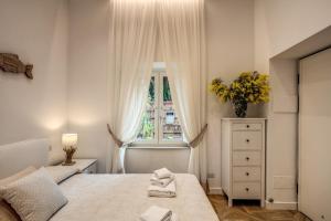 a white bedroom with a bed and a window at Sorrento Square Suites in Sorrento