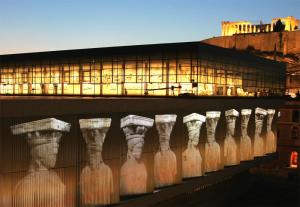 a lit up building with a row of glass bottles at ACROPOLIS MUSEUM APARTMENT in Athens
