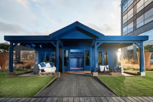 a blue house with two white chairs on a deck at Van der Valk Hotel Brussels Airport in Diegem +47 photos