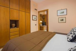a bedroom with a bed and a wooden cabinet at Carla Suite Sorrento in Sorrento