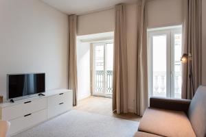 uma sala de estar com uma televisão e um sofá em ALTIDO Elegant Liberdade Apartments em Lisboa