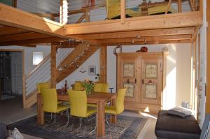 a dining room with a wooden table and yellow chairs at Alpenparadies in Beatenberg