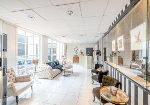 a living room with couches and chairs and tables at Hotel La Legende in Brussels
