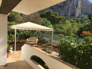un patio con una mesa y una sombrilla blanca en due passi dal mare, en San Vito lo Capo