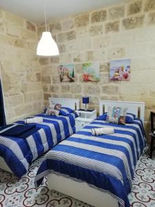 a bedroom with two beds and a stone wall at Sixty Two 3 in Victoria