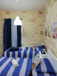 two beds in a room with blue and white stripes at Sixty Two 3 in Victoria