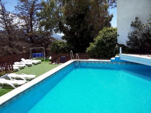 a large blue swimming pool with chairs and a goal at Cortijo Buena Vista in Laroles