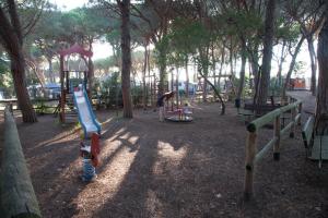 a child playing in a park with a playground at Camping Village Il Sole in Marina di Grosseto