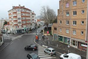a city street with cars parked on the street at Studios Galaxia in Fontenay-sous-Bois