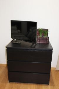 a black dresser with a tv on top of it at Studios Galaxia in Fontenay-sous-Bois