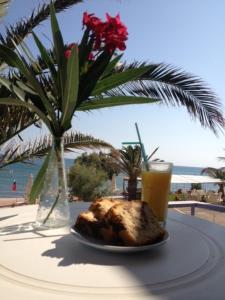 a table with a plate of food and a glass of orange juice at Kefalonia Beach Hotel & Bungalows in Lixouri