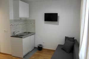 a kitchen with a sink and a couch in a room at Studios Galaxia in Fontenay-sous-Bois
