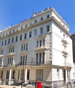 - un grand bâtiment blanc dans une rue de la ville dans l'établissement Kensington Gardens, à Londres