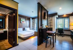 a hotel room with a bed and a desk and a table at Ratana Hotel Chalong in Rawai Beach